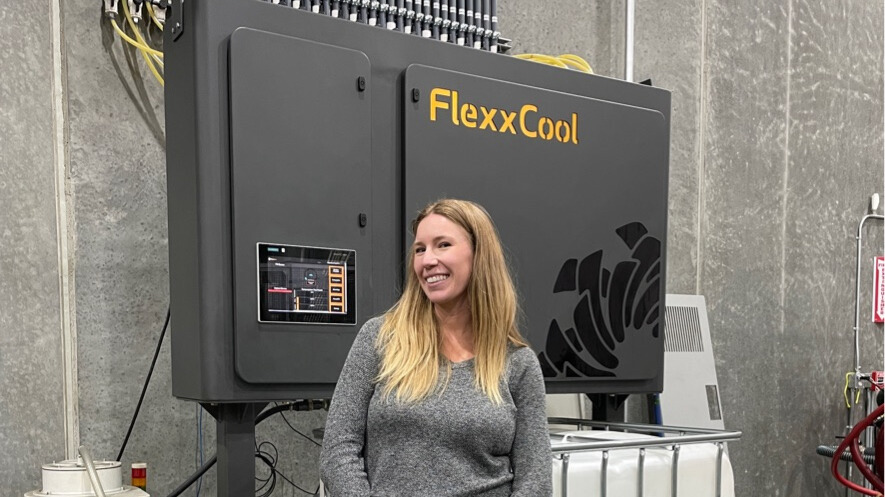 Michelle Standing in front of a FlexxCool System in a machine shop